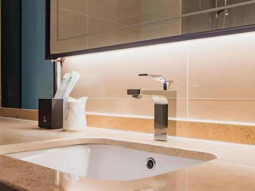 ein Waschbecken mit einem Wasserhahn auf der Theke in der Unterkunft City Comfort Inn Dongguan Wangniudun in Zhongtang