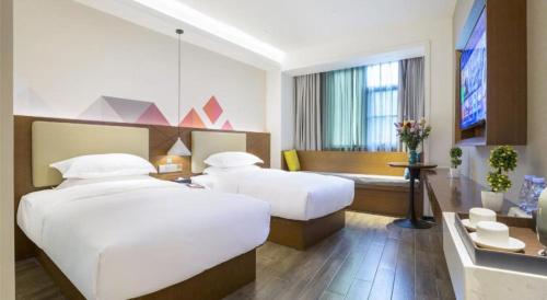 Postel nebo postele na pokoji v ubytování Borrman Hotel Guangzhou Southern Hospital Meihuayuan Metro Station