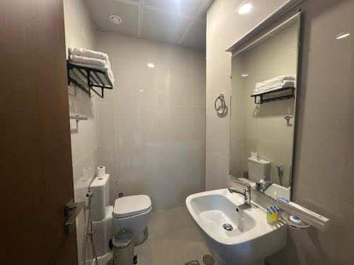 富查伊拉Dream Point Hotel的浴室里有洗手池、马桶和镜子。