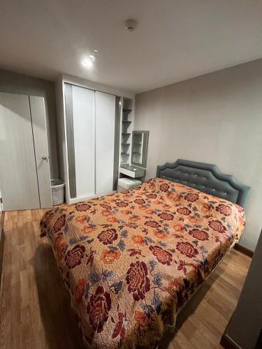 une chambre avec un lit avec un couvre-lit fleuri dans l'établissement AC Home 2 Laksi, à Lak Si