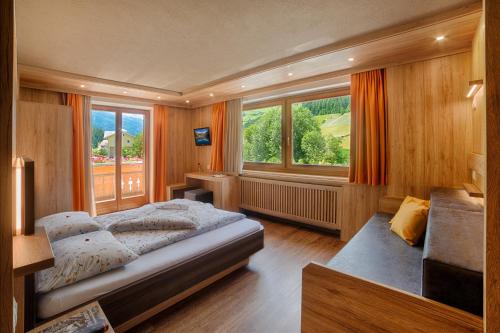a bedroom with a bed and a large window at Pension Brugghof in San Giovanni in Val Aurina