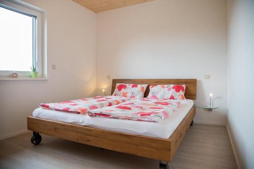 ein Schlafzimmer mit einem großen Bett mit rot-weißer Bettwäsche in der Unterkunft Ferienwohnung im Illertal in Altenstadt