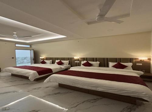 two beds in a large bedroom with a ceiling at The Silk Route Resort in Chanderi