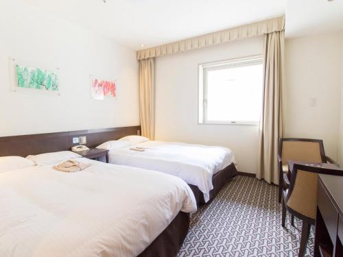 a hotel room with two beds and a window at Hearton Hotel Higashi-Shinagawa in Tokyo