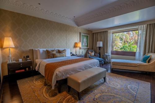 a large bedroom with a large bed and a chair at The Leela Palace Udaipur in Udaipur