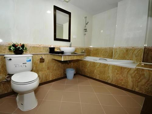 ein Badezimmer mit Toilette, Waschbecken und Badewanne in der Unterkunft Piyaporn Pavilion Hotel in Mae Sai