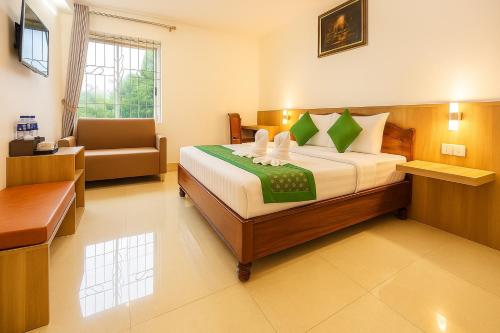 une chambre avec un lit et une chaise dans une pièce dans l'établissement The One by Nika, à Siem Reap