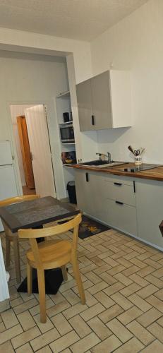 a kitchen with a table and a small table in it at entre plage et palais in Fécamp