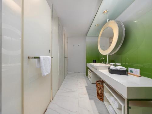 un baño con lavabo y espejo en Metropolo Dahua Hotel Shanghai, en Shanghái