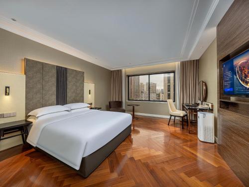Un dormitorio con una cama blanca grande y un escritorio en Metropolo Dahua Hotel Shanghai, en Shanghái
