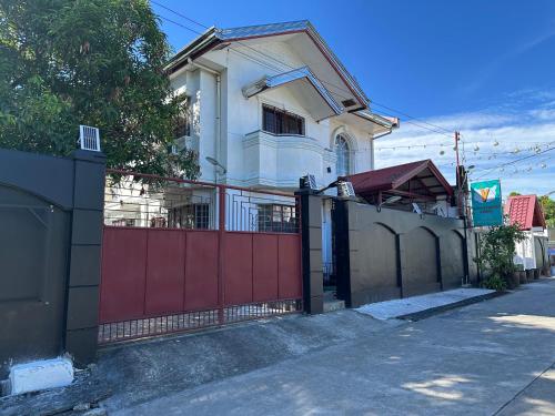 a house with a red gate and a fence at Del Mar Residence 1 in Suizo