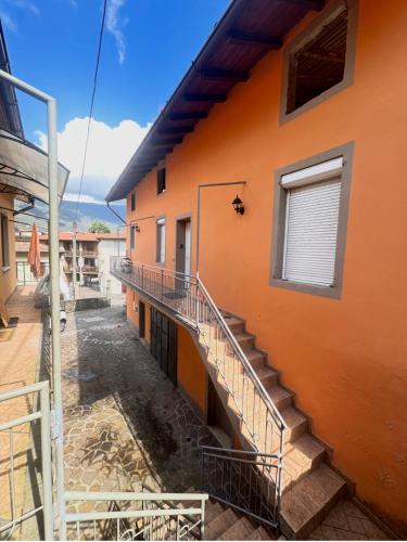 an orange building with stairs and a window at La Casa di Erika in Monasterolo del Castello