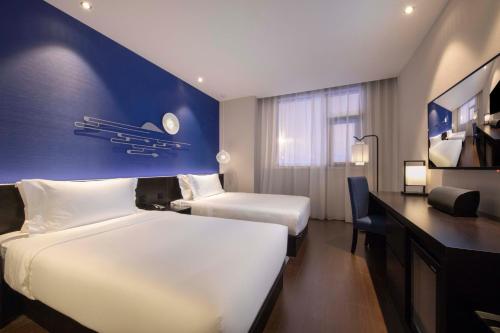 Una cama o camas en una habitación de Orange Hotel