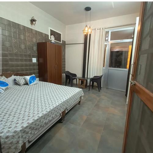 une chambre avec un lit et une table avec des chaises dans l'établissement Silor mahadev home stay, à Almora