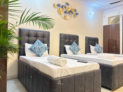 Cette chambre comprend 2 lits avec des oreillers bleus et blancs. dans l'établissement Hotel Divine India Near Expo Center, à Greater Noida