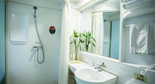 ein weißes Badezimmer mit Waschbecken und Spiegel in der Unterkunft GreenTree Inn Luoyang Zhongzheng Street Express Hotel in Luoyang