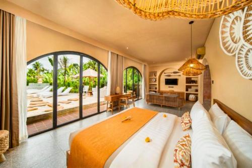 a bedroom with a large bed and a large window at Neona Spacious 4 BR Private Pool Villa ZN364 in Tanah Lot