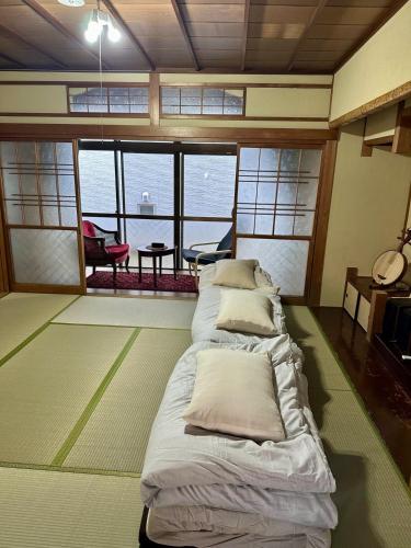 a room with a bed with pillows on the floor at Tora House in Nagoya