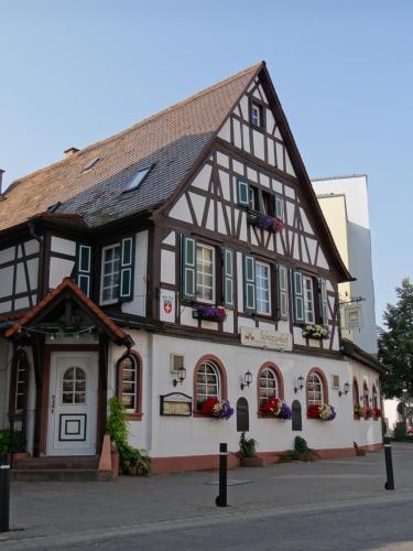 a half timbered building with green shuttered windows at Hotel Schützenhof mit Klimaanlage in Bürstadt