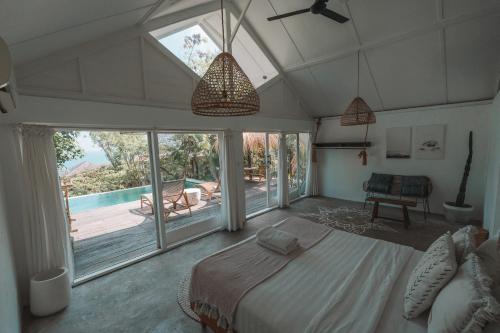a bedroom with a bed and a large window at Light The Path Bali in Uluwatu