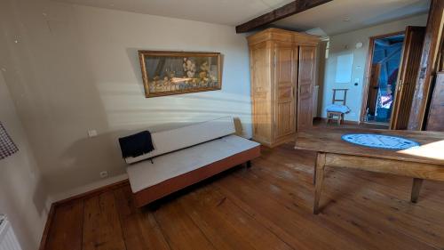 ein Wohnzimmer mit einer Bank und einem Wandgemälde in der Unterkunft Les Perles du Ried - Gîte 206 in Boofzheim