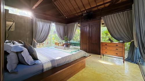 a bedroom with a large bed and a window at Maso Christian Villa Canggu in Tumbak Bayuh