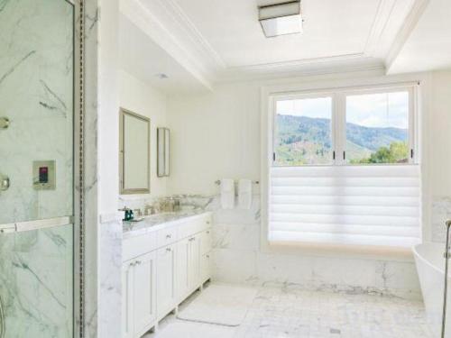 La salle de bains blanche est pourvue d'une douche et d'une fenêtre. dans l'établissement Hotel Jerome, An Auberge Resort, à Aspen