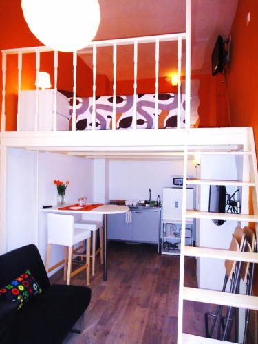 une chambre avec un lit mezzanine, une table et une cuisine dans l'établissement Orange Suite Studio, à Amsterdam