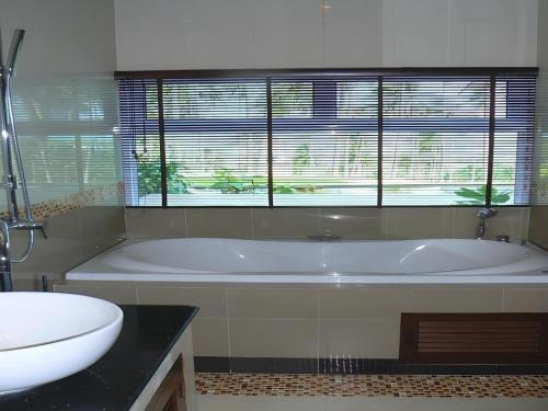 ein Badezimmer mit Badewanne, Toilette und Waschbecken in der Unterkunft Grand Hill Residence in Ban Tai