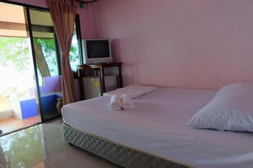 ein Schlafzimmer mit einem Bett mit zwei Handtüchern darauf in der Unterkunft Roong Arun Resort in Pumriang