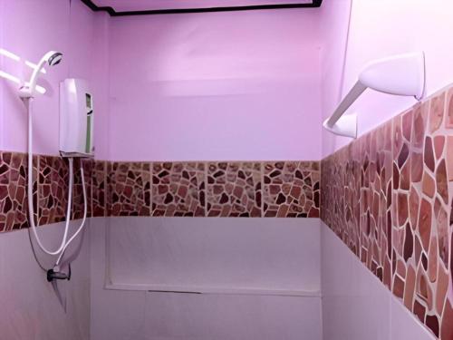 ein Bad mit Dusche und braunen Wandfliesen in der Unterkunft Roong Arun Resort in Pumriang