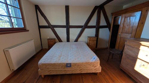 ein Schlafzimmer mit einem Bett und einem Holzboden in der Unterkunft Les Perles du Ried - Gîte 207 in Boofzheim