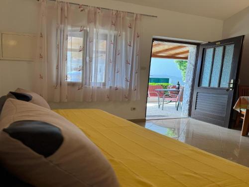 a bedroom with a bed and a door to a patio at Apartments Magdalena - Bungalow with terrace A1 in Bol