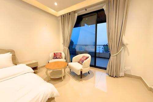 une chambre avec un lit, une chaise et une fenêtre dans l'établissement Luxury Studio at Monal Murree Balcony with Private Parking, à Murree