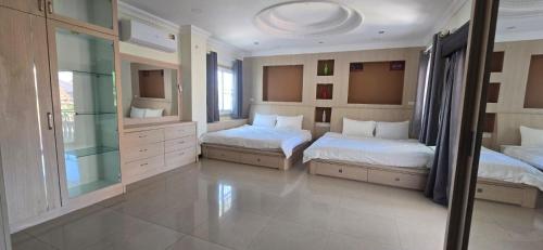 2 Betten in einem großen Zimmer mit Spiegeln in der Unterkunft Ketki Luxury Pool Villa PearlShore Pattaya in Pattaya South
