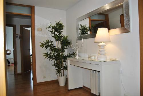 a living room with a table with a lamp and a mirror at Parque Nacoes Prime Apartments 13 in Lisbon