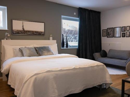 a bedroom with a large white bed and a chair at Beautiful house close to center in Gothenburg
