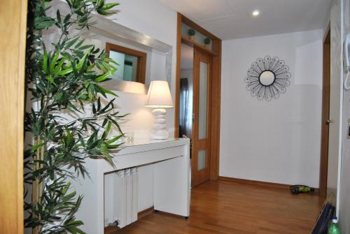 a hallway with a table with a lamp and a plant at Parque Nacoes Prime Apartments 13 in Lisbon