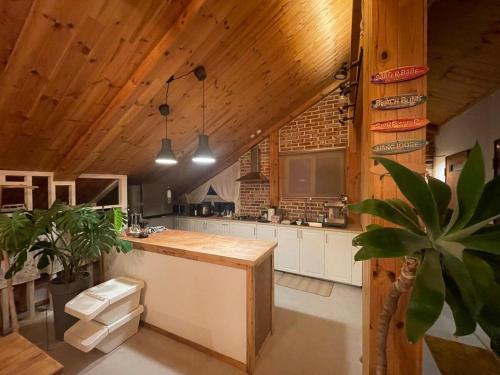 Il comprend une cuisine dotée de plafonds en bois et d'un comptoir en bois. dans l'établissement LaniKai Full oceanview stay, à Namae-ri