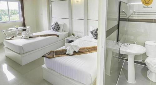 ein weißes Badezimmer mit zwei Betten und einem Waschbecken in der Unterkunft The Rich Residence in Ban Tha Kup