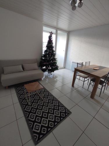 ein Wohnzimmer mit einem Weihnachtsbaum und einem Tisch in der Unterkunft Appartement à la mer in Saint-Hilaire-de-Riez