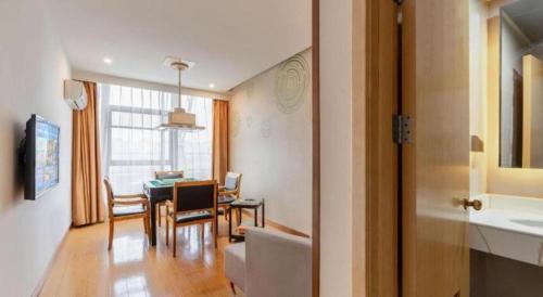 a kitchen and dining room with a table and chairs at GreenTree Inn Suzhou Changshu North Haiyu Road Changhui Square Express Hotel in Changshu