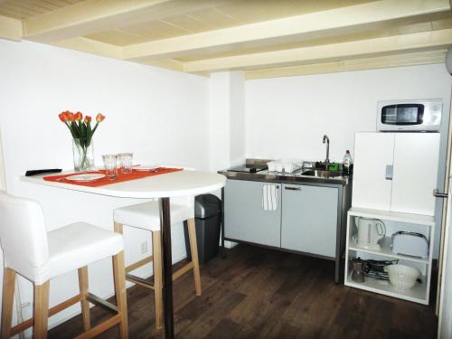 une cuisine avec une table blanche et un réfrigérateur blanc dans l'établissement Orange Suite Studio, à Amsterdam
