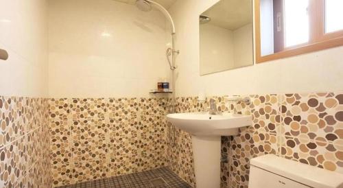 ein Badezimmer mit Waschbecken, Toilette und Spiegel in der Unterkunft CJ Tourist Hotel in Jeju-do