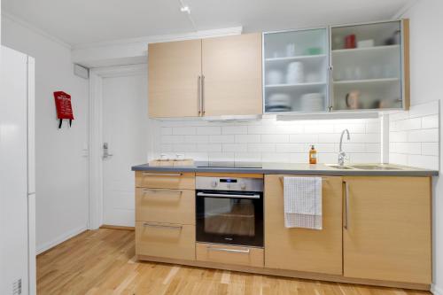 Una cocina con gabinetes de madera y un horno de estufa. en Arctic hilltop lodge - Room 2, en Guleng