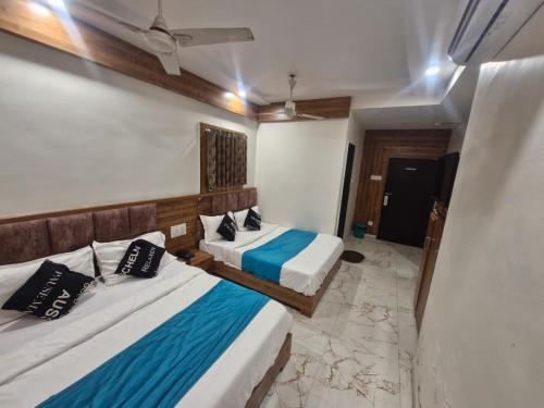 Dos camas en una habitación de hotel con dos en Hotel Signature, en Ahmedabad