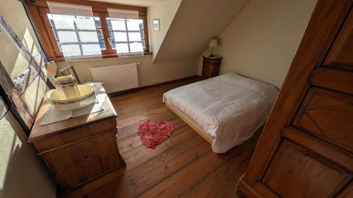 a small bedroom with a bed and a wooden floor at Les Perles du Ried - Gîte 209 in Boofzheim