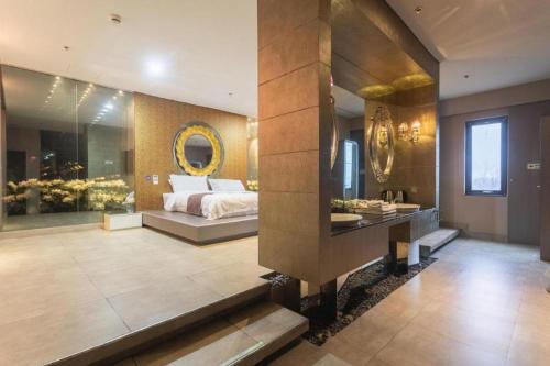 a bedroom with a bed and a mirror on the wall at Qingdao Hengbo Hotel in Qingdao
