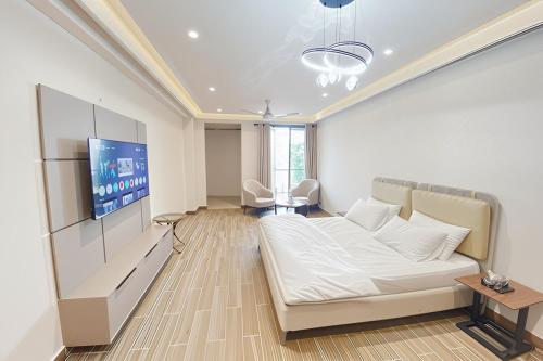 a living room with a couch and a tv at Luxury Studio at Monal Murree with Mountain Views in Murree