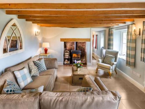 un salon avec un canapé et une cheminée dans l'établissement Fursdon Cottage, à Cadbury